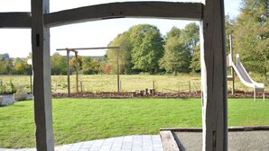 A park with a playground, including a slide and swings, under a wooden pavilion. - Group Villa With Sauna (Erezee)