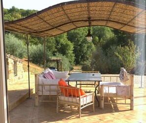 An outdoor seating area with a thatched roof, a table, and two chairs. - Villa in Cortona With Private Pool (Magione)