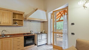 A kitchen with wooden cabinets, a stove, and a sink.