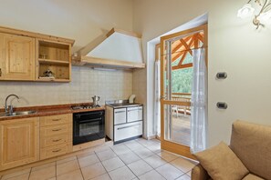 A kitchen with wooden cabinets, a stove, and a sink.