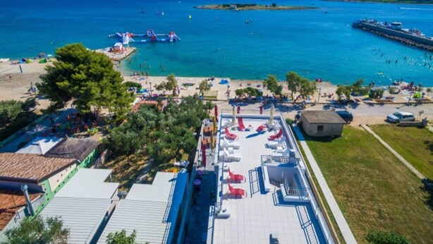 A coastal hotel with a rooftop pool area, beach access, and a view of the sea. - Modern Apartment in Pakostane With Barbecue (Pakostane)