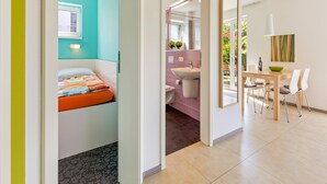 Une chambre d’hôtel moderne comprenant un lit, une salle de bain et un coin repas.