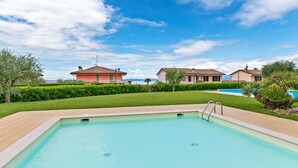 Ein Swimmingpool mit blauem Himmel und zwei Häusern im Hintergrund.