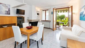 Eine moderne Küche mit Essbereich, einer Couch und Blick auf den Garten.