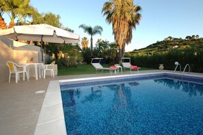 A swimming pool with lounge chairs and a table, surrounded by palm trees and a hilly landscape. - Holiday Home With Private Pool, Near the Beach (Trappeto)