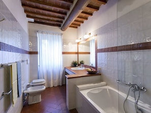 A bathroom with a bathtub, a toilet, and a sink.