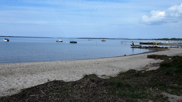 A beach with boats on the water and a dock. - Modernes Ferienhaus in Boiensdorf am Meer (Boiensdorf)