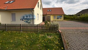 A building with a red-tiled roof and a mural on the side. - Modernes Ferienhaus in Boiensdorf am Meer (Boiensdorf)