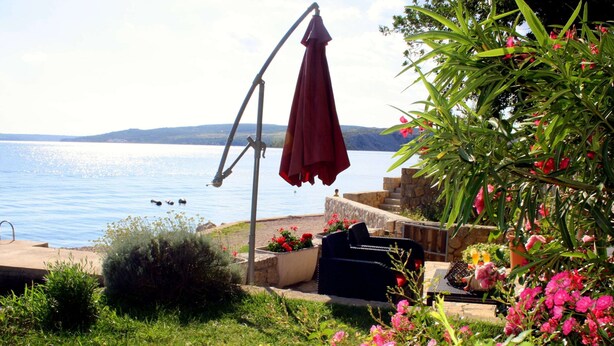A patio with outdoor furniture, a swing, and a view of the sea. - Scenic Apartment in Maslenica With Terrace (Jasenice)