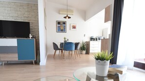 A modern living space with a dining area, kitchen, and a TV. - Scenic Apartment in Maslenica With Terrace (Jasenice)