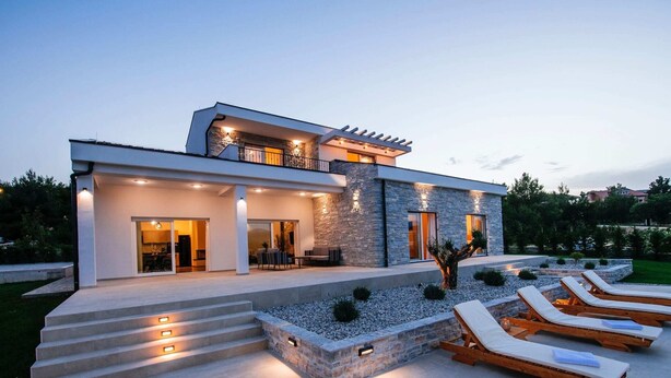 A modern house with a spacious patio, outdoor seating, and a well-lit entrance. - Villa With Private Pool and Garden (Novigrad)