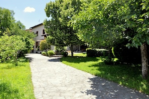 A stone pathway leading to a building surrounded by lush greenery and trees. - Holiday Home Lazise Near Lake Garda (Lazise)