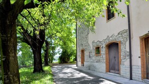 Un sendero que conduce a un edificio de piedra con ventanas de arco y una puerta de madera.