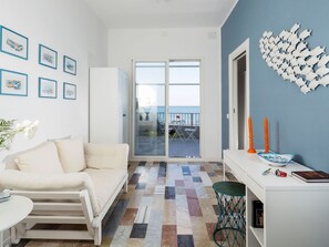 Relax in a stylish room with a sofa, desk, and balcony offering a sea view.