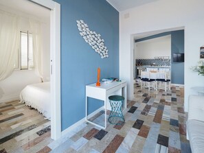 Cozy retreat with a comfortable white bed, a small dining area, and a mounted TV.