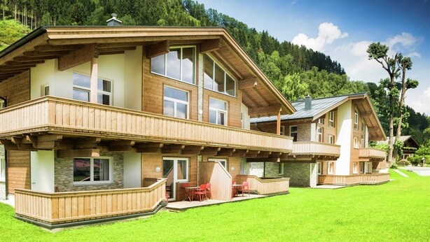 A two-story wooden house with balconies, large windows, and a stone facade. - Majestic Apartment in Zell am See near Ski Area (Zell am See)