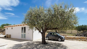 A small white building with a car parked in front. - Belvilla by OYO Villa Kika (Noto)