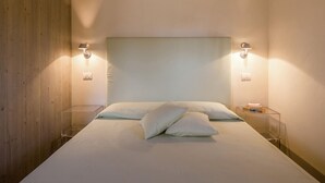 A minimalist bedroom with a large bed, two bedside tables, and wall-mounted reading lights. - Villa with Spacious Garden, Swimming Pool, Hot Tub, Tennis Court near Cortona (Cortona)