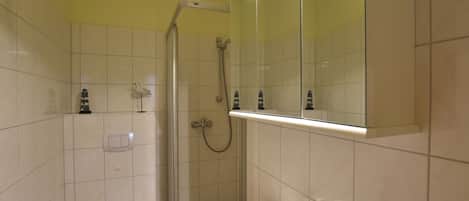 A bathroom with a toilet, sink, and shower.