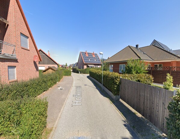 A residential street with houses, a clear sky, and solar panels on one roof. - Ferienwohnung in Zierow mit Garten (Zierow)