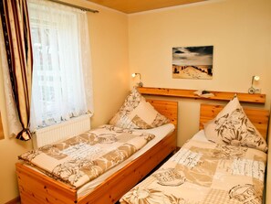A double bed with floral bedding, a bedside table with a lamp, and a wall-mounted picture. - Cozy Holiday Home in Kägsdorf near Sea (Bastorf)