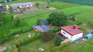 A rural property with a large house, a barn, and expansive green fields.