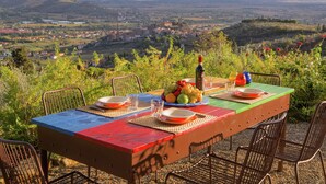 Une table dressée à l’extérieur, avec vue sur une vallée.