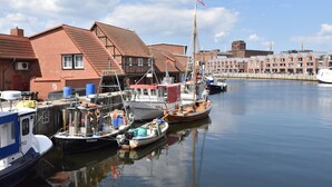 A harbor with boats docked, buildings with red roofs, and a clear sky. - Gemutliches Appartement in Zierow mit Aussenkamin (Zierow)