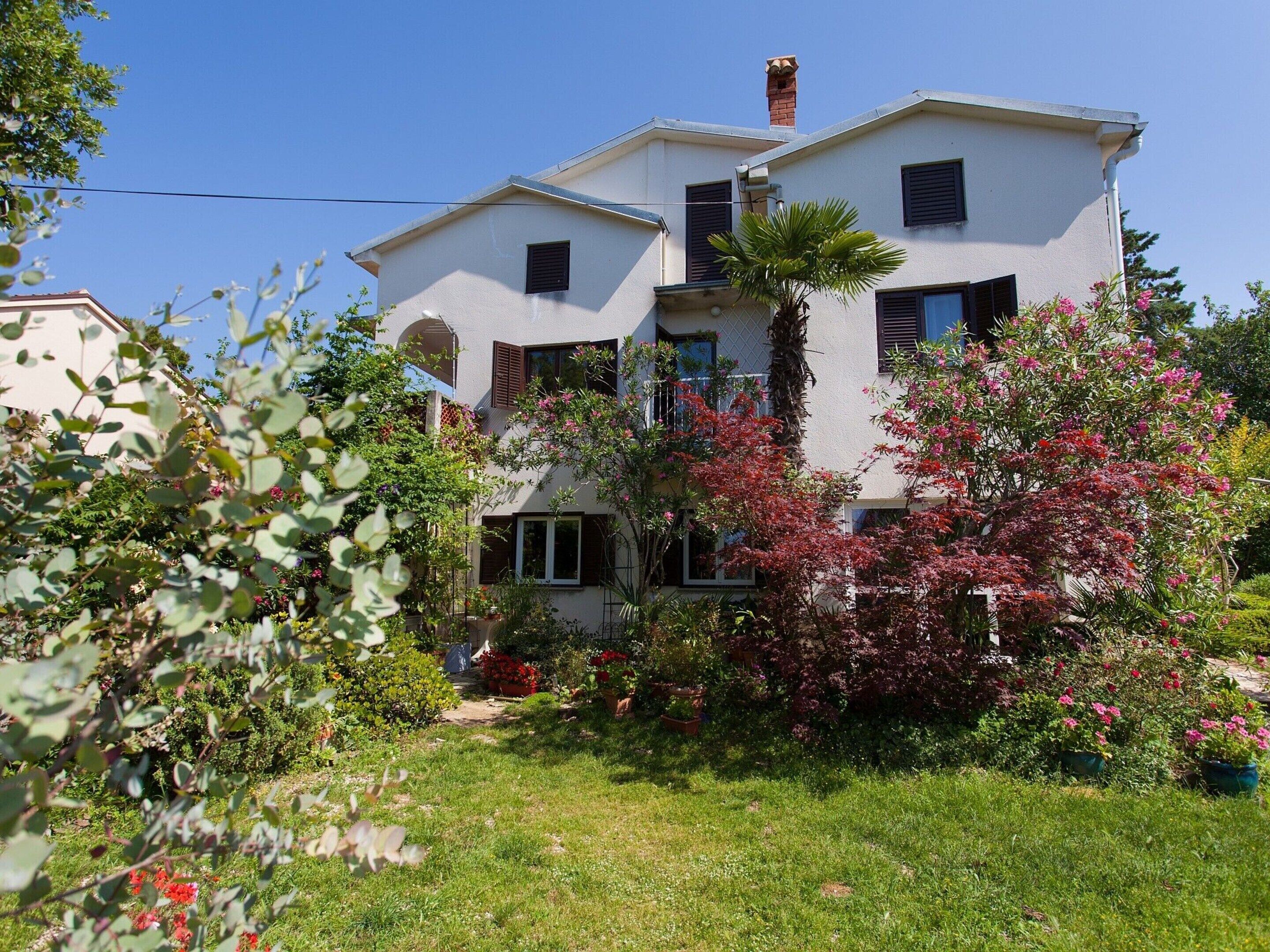 A two-story house with a garden in front.