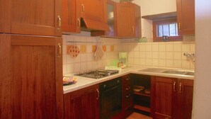 A kitchen with wooden cabinets, a stove, and a sink. - Cottage in Cortona With Pool & Stunning Views (Cortona)