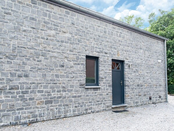 A stone building with a dark door and a small window.