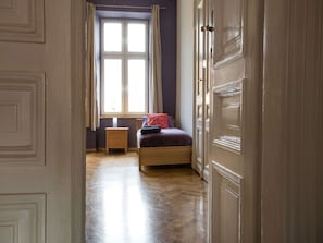 Ein Schlafzimmer mit einem Bett, einem Nachttisch und einem Fenster mit Vorhängen.