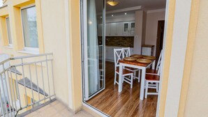 Ein Balkon mit einer Glastür und Zugang zu einer Küchenzeile.