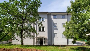 A modern building with a flat roof, multiple windows, and a central entrance. - Modern Apartment in Viskovo With Balcony (Viskovo)