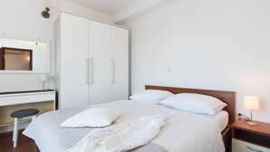 A hotel room with a bed, a desk, a wardrobe, and a nightstand. - Holiday Home in Podstrana Near Beach (Podstrana)