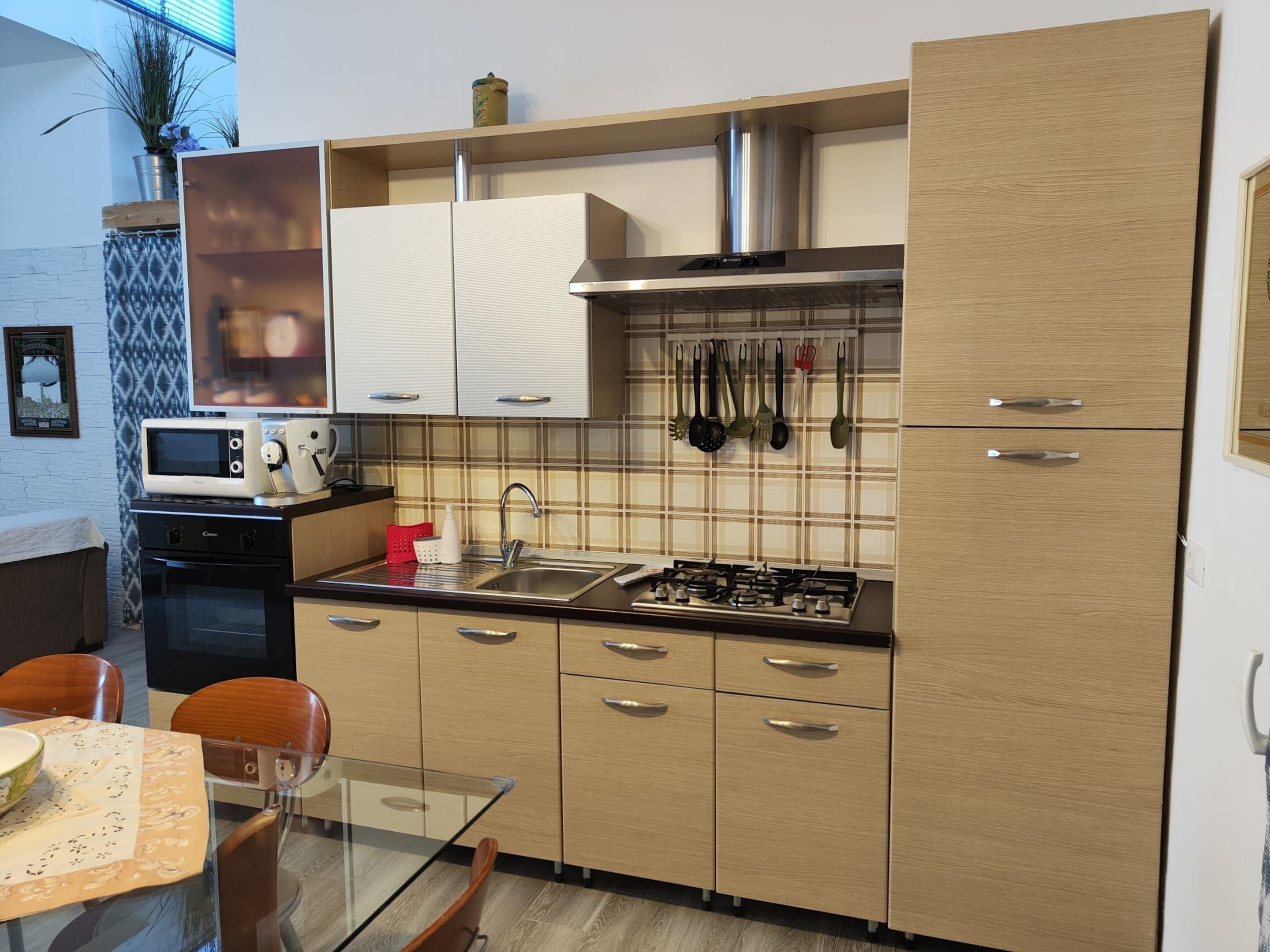A modern kitchen with a gas stove, microwave, and stainless steel sink.