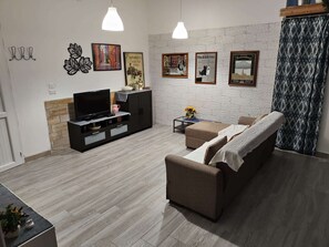 Ein Wohnzimmer mit Fernseher, Sofa und Couchtisch.