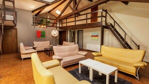 A spacious loft-style living area with high ceilings, exposed wooden beams, and a mezzanine level. - Ouffet Villa With Sauna, Liege (Ouffet)