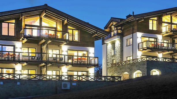Ein mehrstöckiges Hotel mit Balkonen, großen Fenstern und einer Steinfassade.