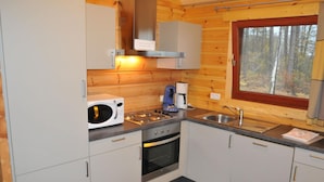 A compact kitchen with a microwave, coffee maker, and stove. - Apartment in Belgium Near Scenic Spots (Viroinval)