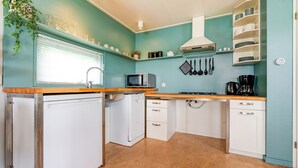 A compact kitchen with a refrigerator, microwave, stove, sink, and white cabinets. - Elegant Chalet in Anjum near Lauwersmeer Lake (Anjum)