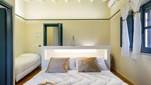 A hotel room with a large bed, a headboard, a mirror, and a window with curtains. - Belvilla by OYO Casale di Benedetto (Caltagirone)