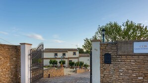 A gated entrance with a stone wall, a sign reading "CDB Casale Di Benevento", and a building with a tiled roof. - Belvilla by OYO Casale di Benedetto (Caltagirone)
