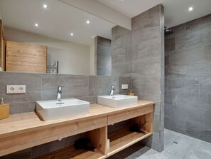 A modern bathroom with two sinks, wooden vanity, and a shower area. - Chalet in Hollersbach / Salzburg Near ski Area (Hollersbach im Pinzgau)