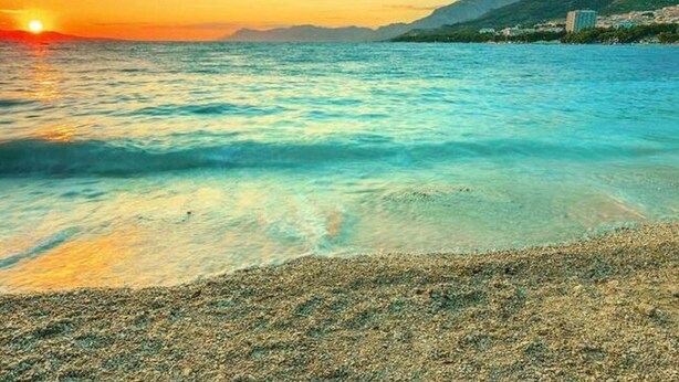 A coastal scene with clear turquoise waters, a pebbly beach, and a mountain range in the background. - Your Perfect Adriatic Getaway (Starigrad)