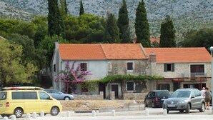 A building with a red-tiled roof, stone walls, and a small balcony. - Your Perfect Adriatic Getaway (Starigrad)