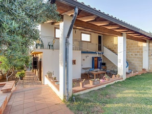 A two-story house with a covered patio, outdoor seating, and a staircase leading to the upper floor. - Villa in Partinico Near the Beach (Partinico)