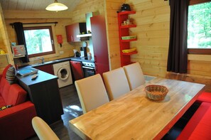 Une petite cabine comprenant un coin repas, une cuisine et un lave-linge.