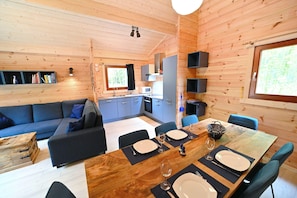 Ein gemütliches Blockhaus mit Essbereich, Küche und Wohnzimmer.