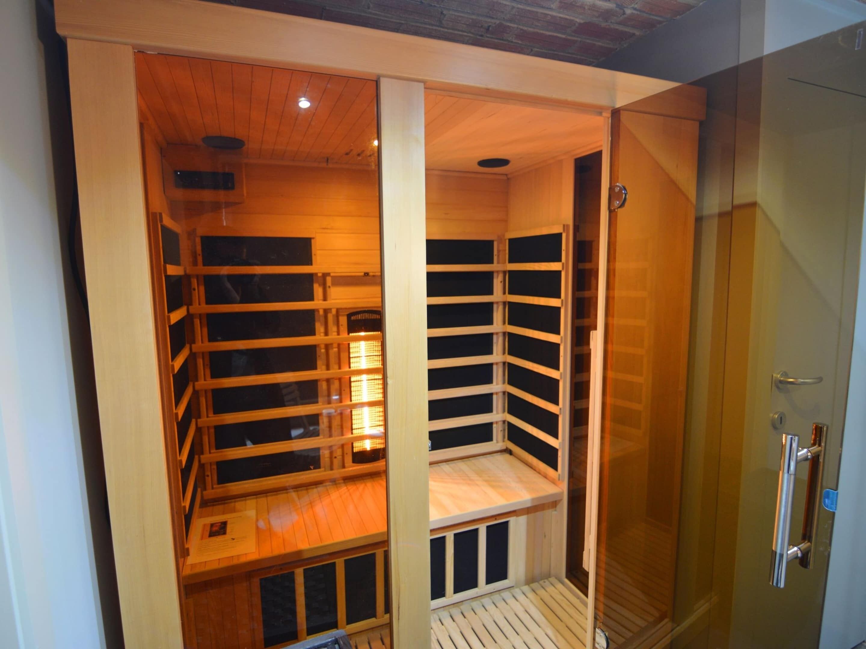 A sauna room with wooden benches and a glass door.